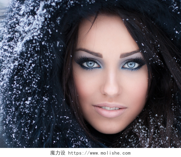 冬天戴着毛茸茸帽子的年轻女子在白雪皑皑的毛茸茸罩的女人